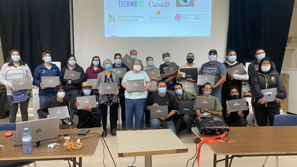 Group of people posing holding laptops at a Digital Literacy Course